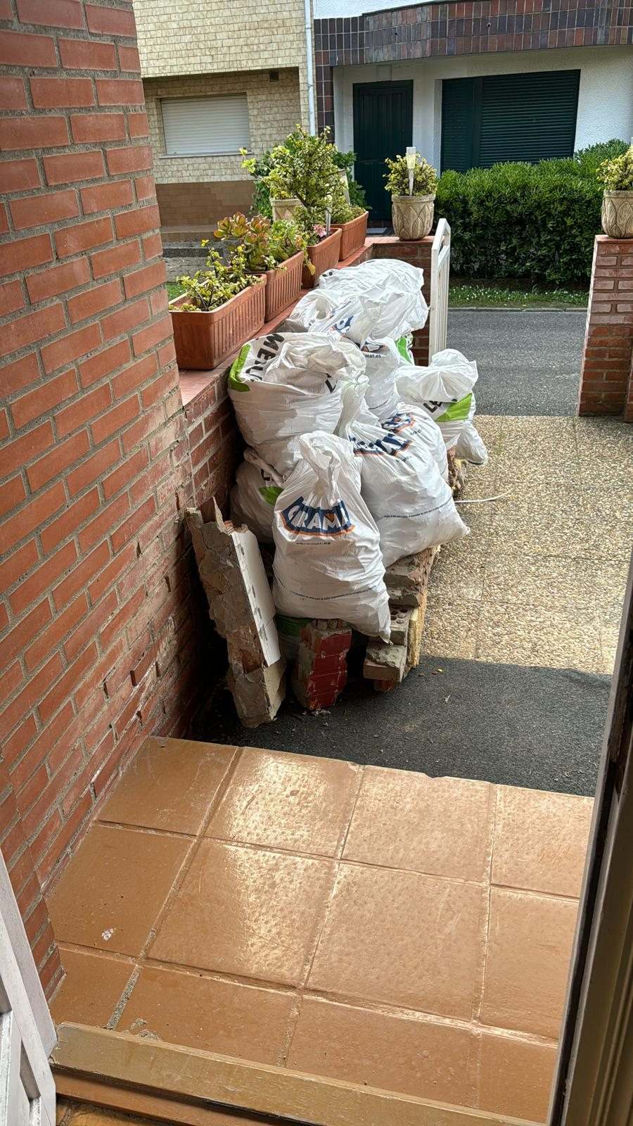 Sacos de escombro apilados a la entrada de la casa