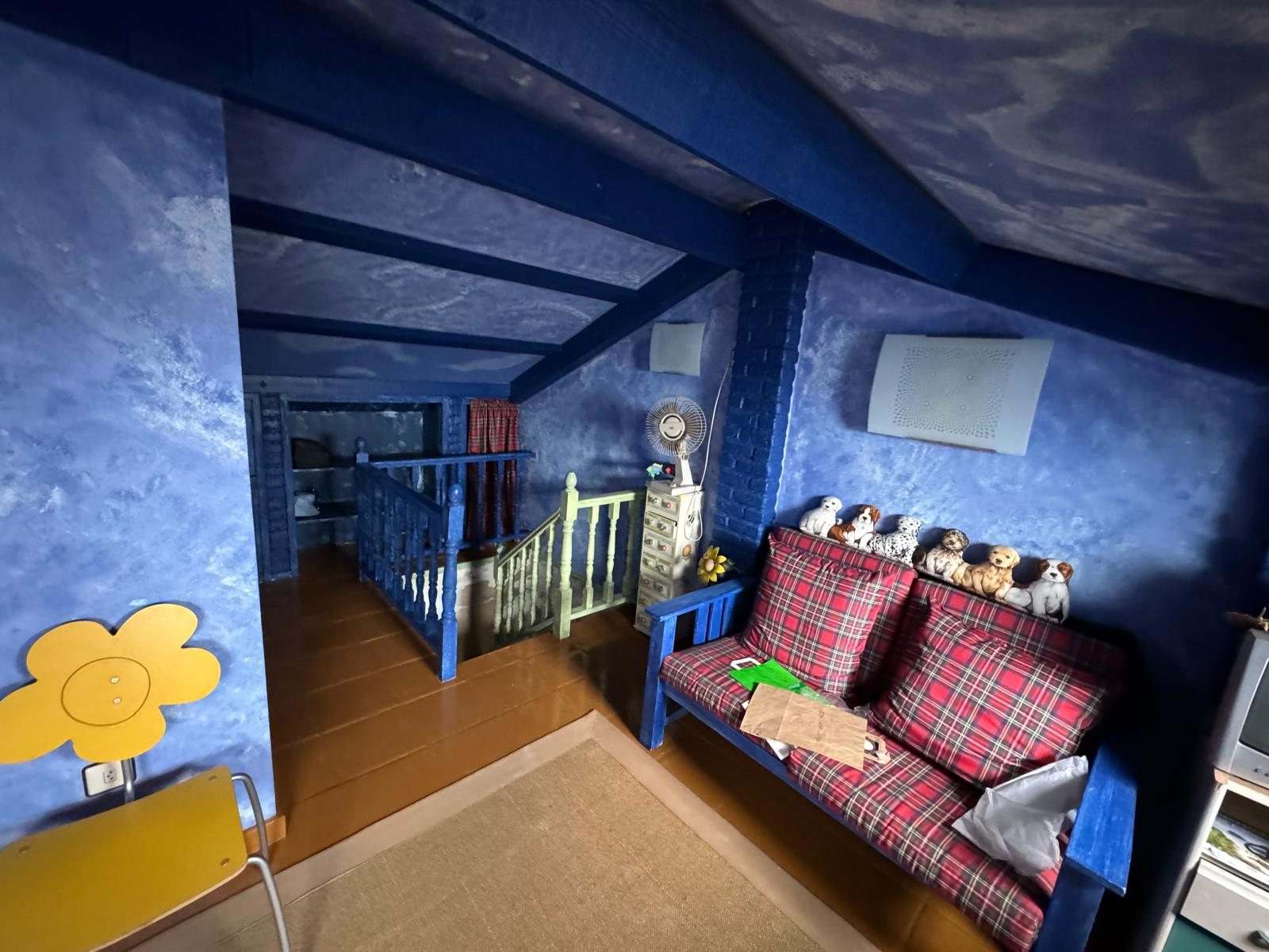Bajocubierta azul con la llegada de la escalera y barandilla de madera