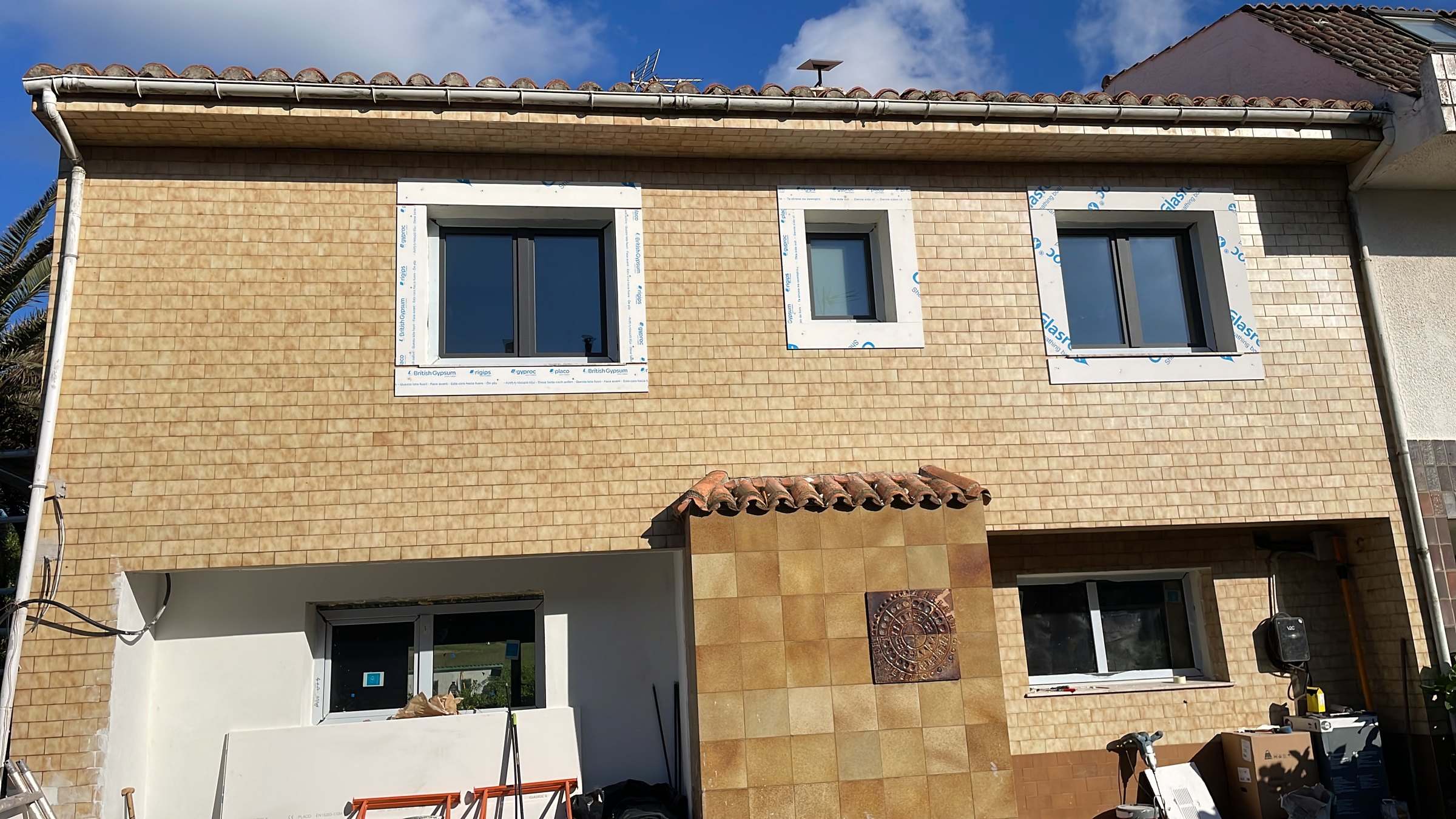Fachada principal con la plaqueta original y los recercados de las ventanas montados, antes de pintar