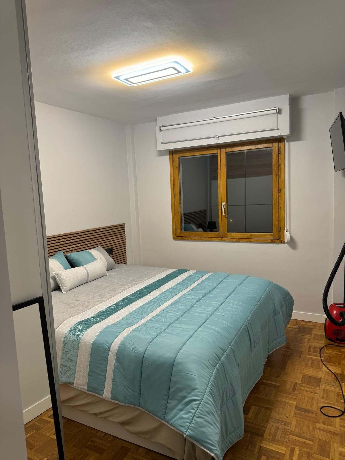 Segundo dormitorio con cabecero de listones, plafón LED y estor