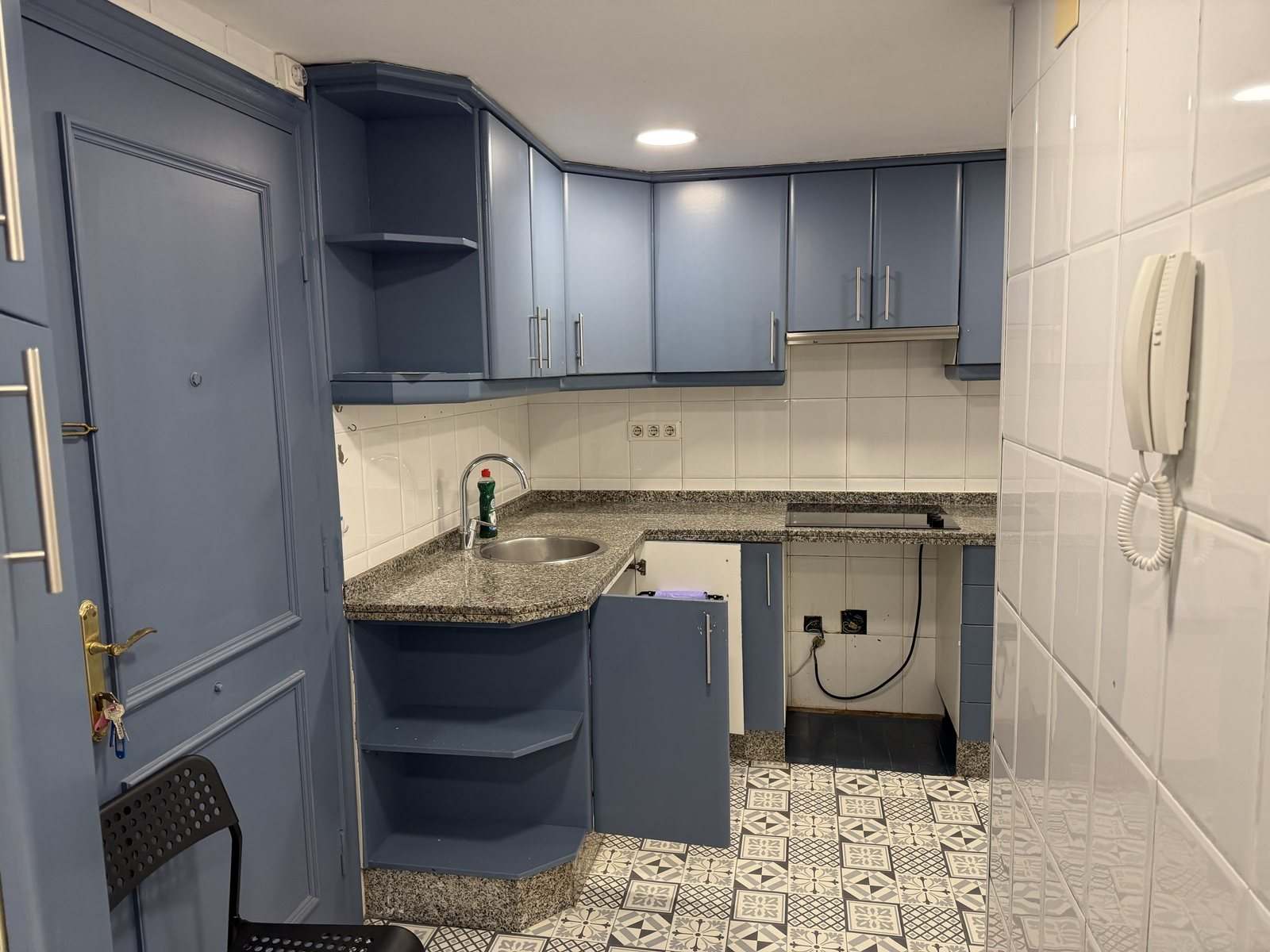 Rincón del fregadero de la cocina con muebles altos azules