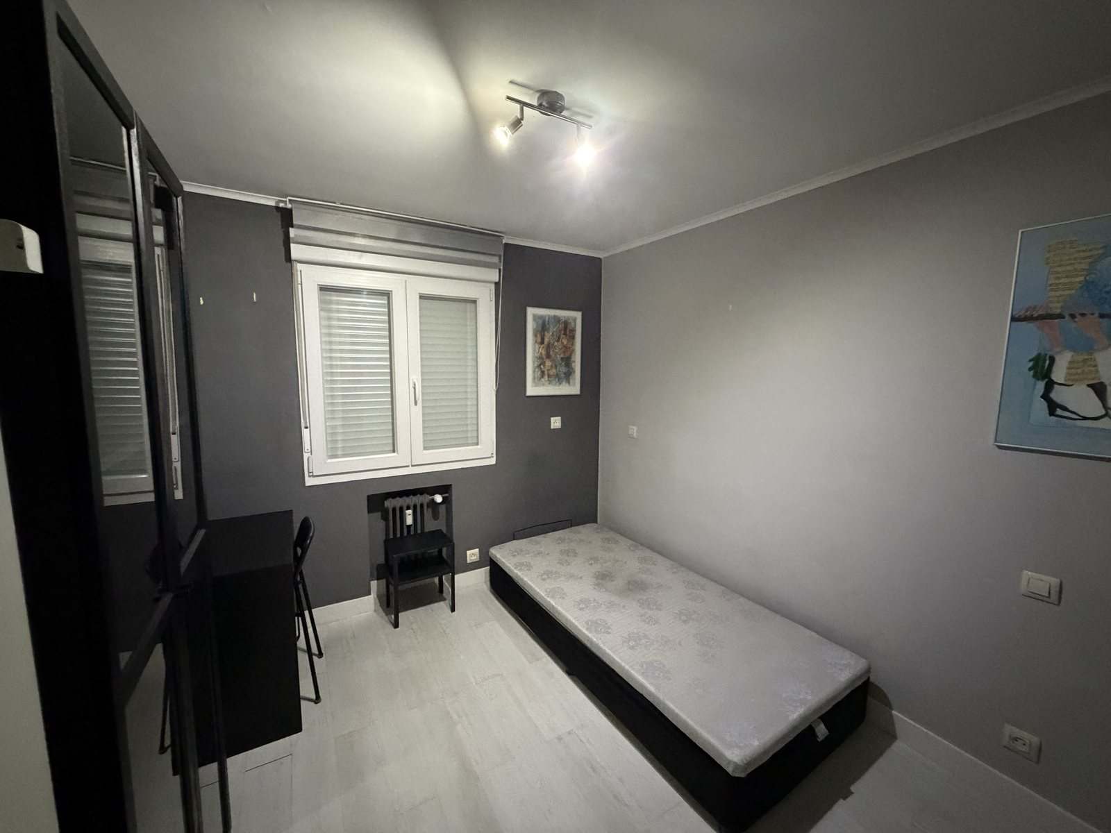 Dormitorio con pared gris oscura, cama individual y escritorio